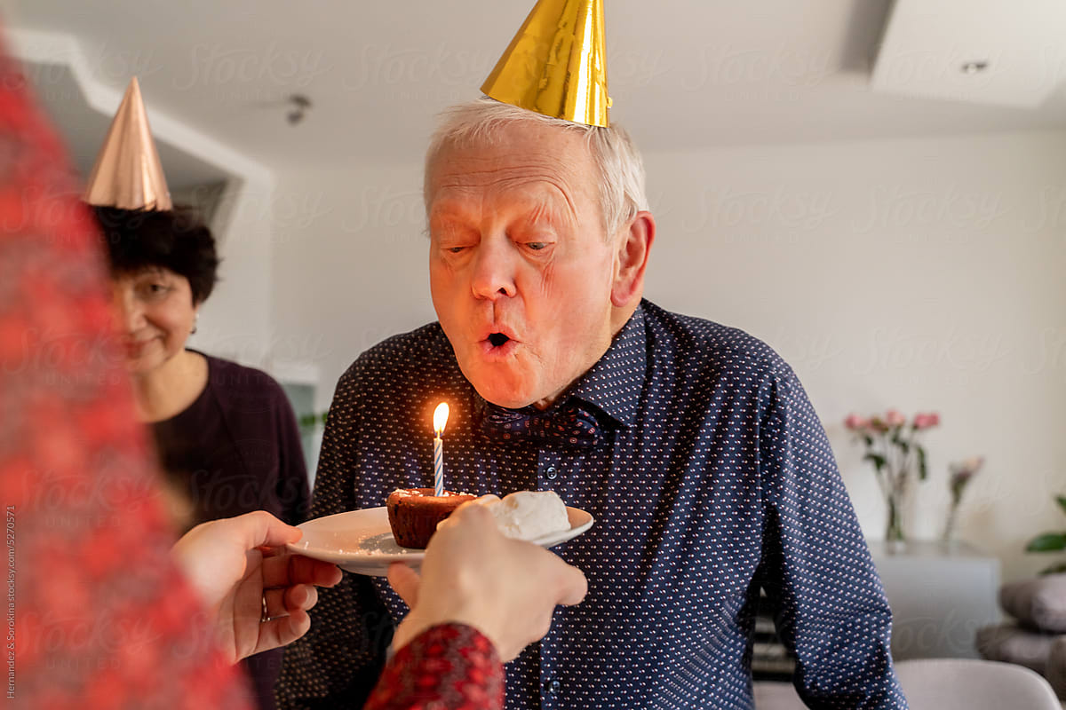 Senior Man Blowing Out Birthday Candle