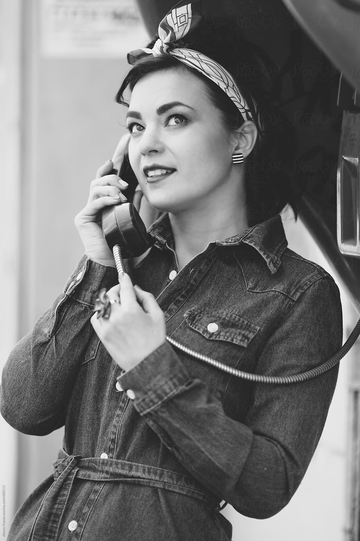 young pin-up woman with vintage street telephone