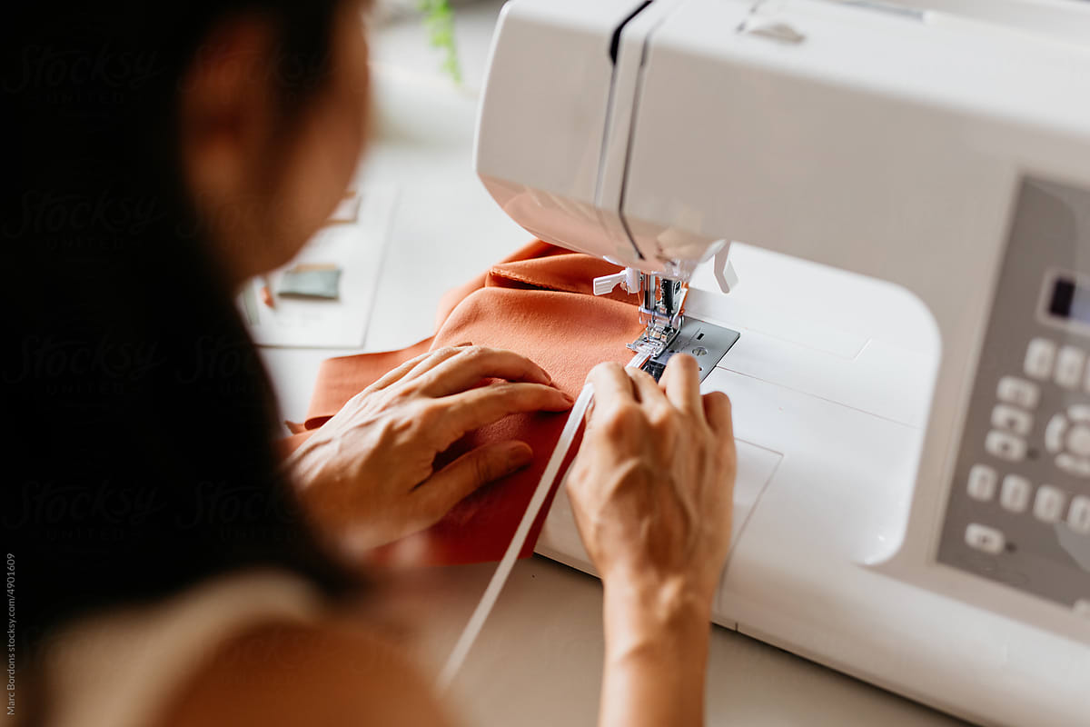 A woman sews a rubber strip