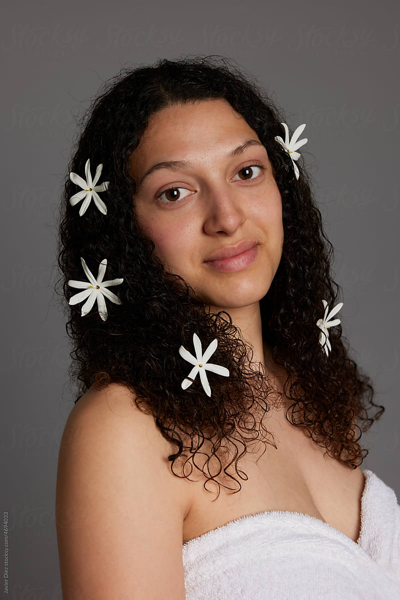 Smiling woman with bare shoulders and flowers in hair