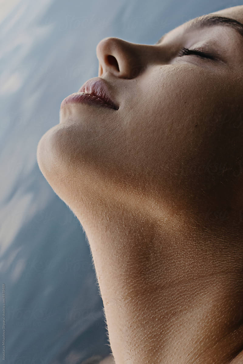 Half face profile portrait of a woman with closed eyes in water