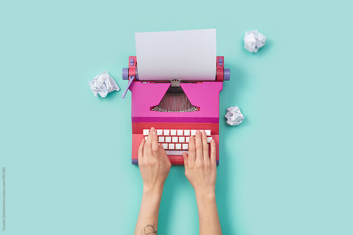 Woman writing on pink vintage typewriter
