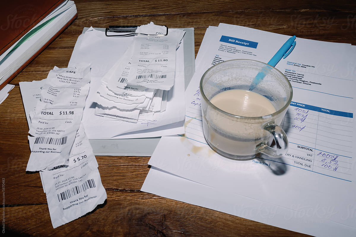 Business Receipts and  coffee with milk Glass on Wooden Table