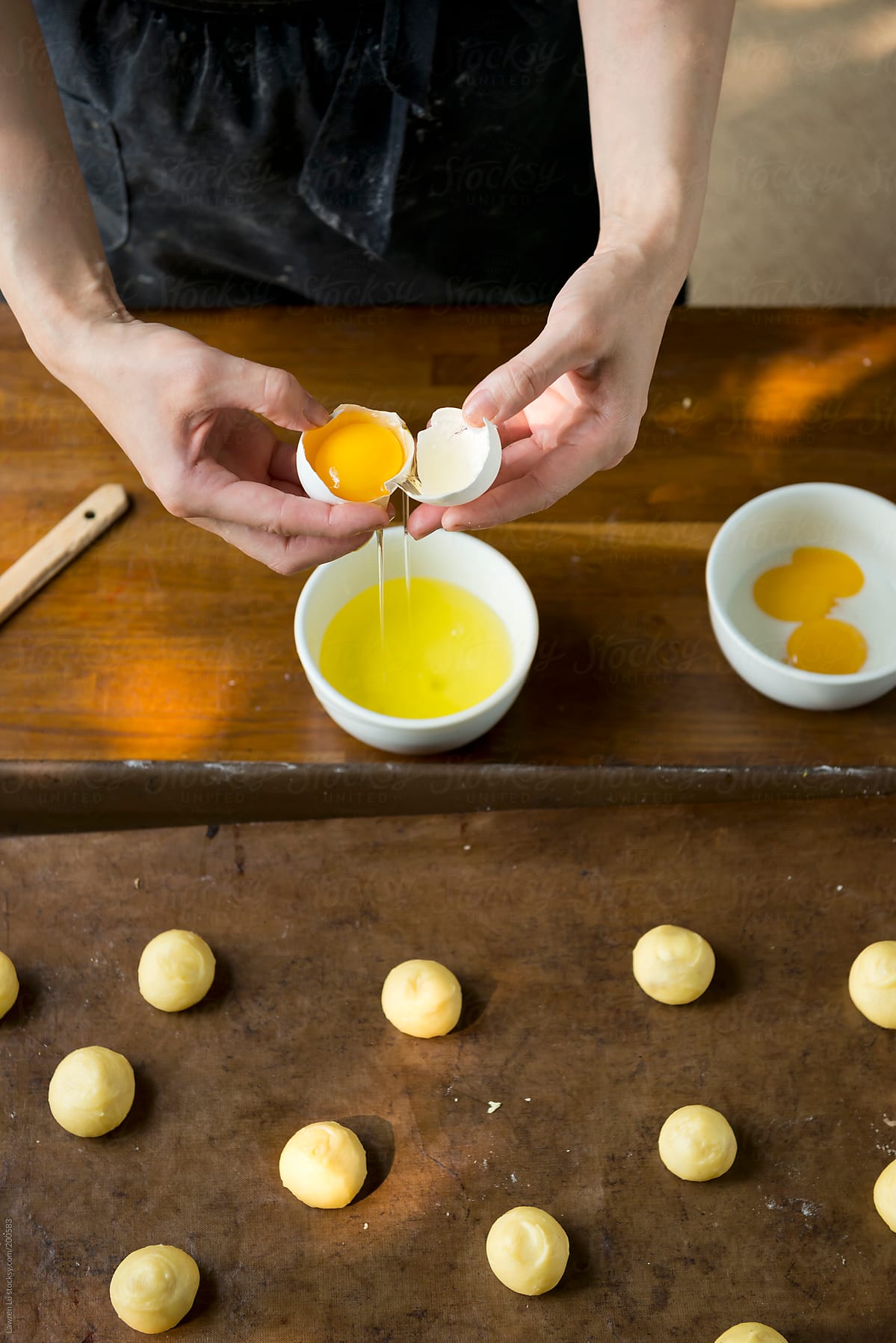 Woman hands separating egg yolk for brushing bread