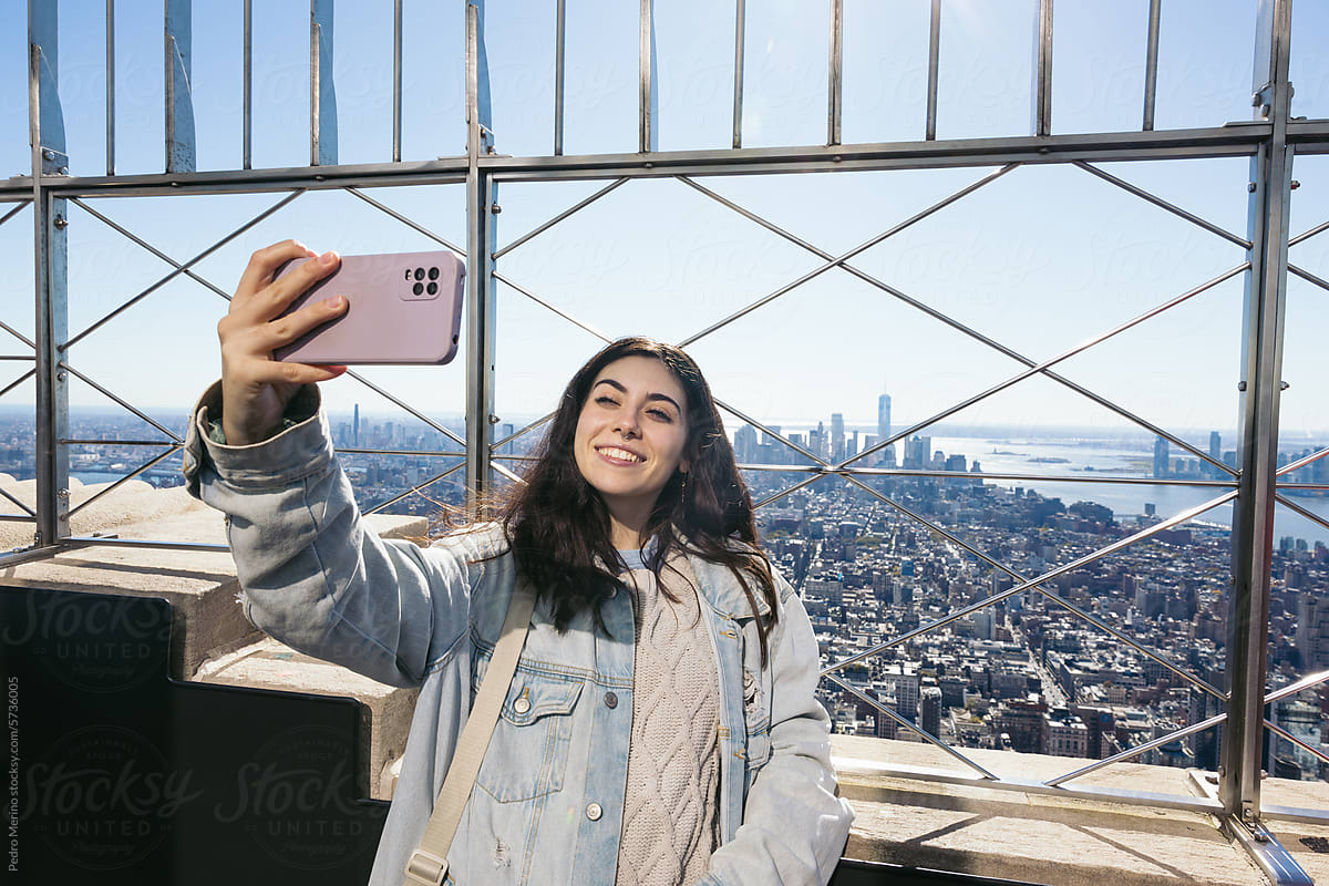 Woman taking selfies with smartphone at the Empire State Building