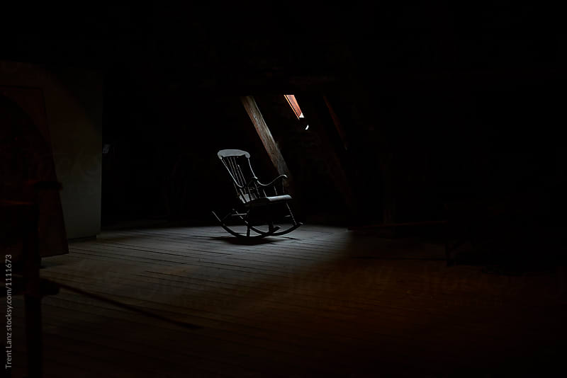 Old rocking chair in dark abandoned attic