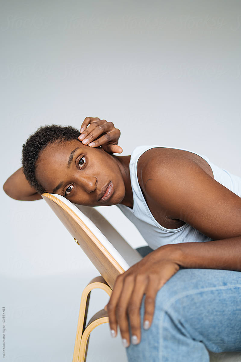young black woman sitting with her face against the back of a chair