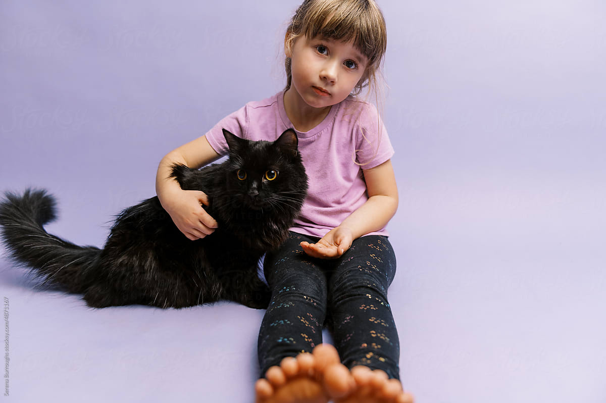 Little girl in purple with her black cat