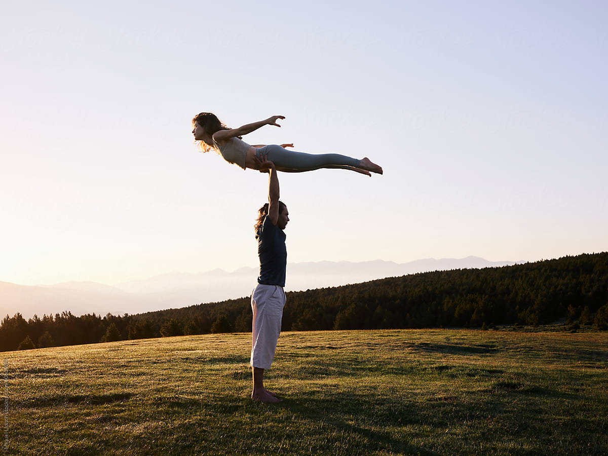 Calm couple practicing yoga in field