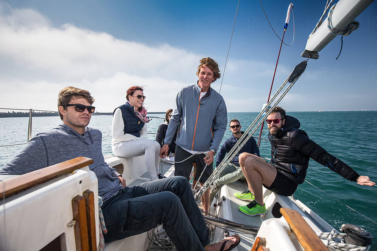 Group of smiling friends sailing on yacht ready for ocean sailboat  adventure