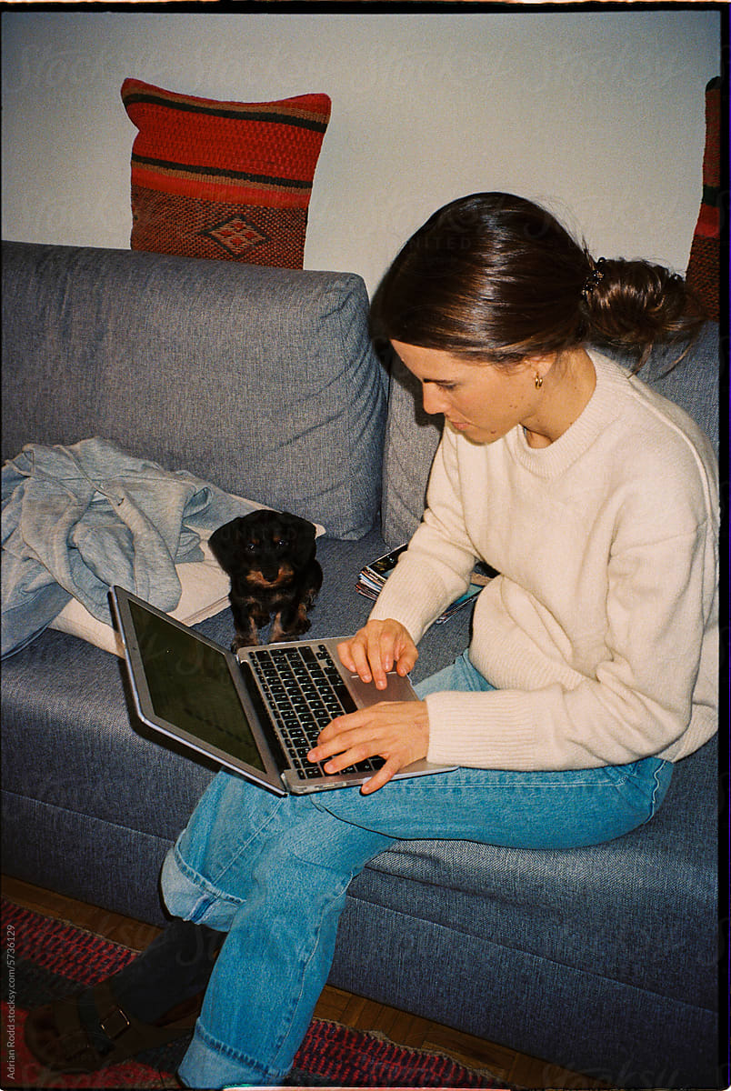 analog portrait of a woman sitting on a sofa using a laptop
