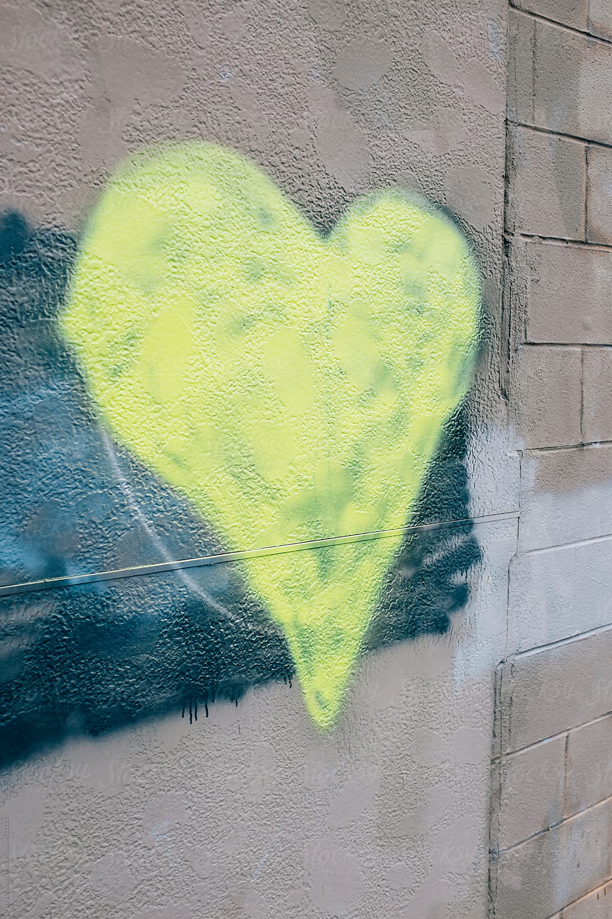 Yellow heart shape painted on wall of building