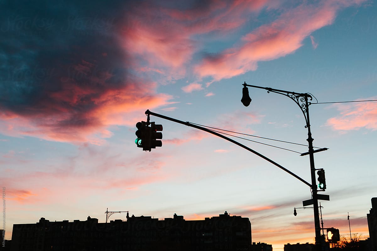 Evening skyline of buildings and traffic light in a city with fiery sunset