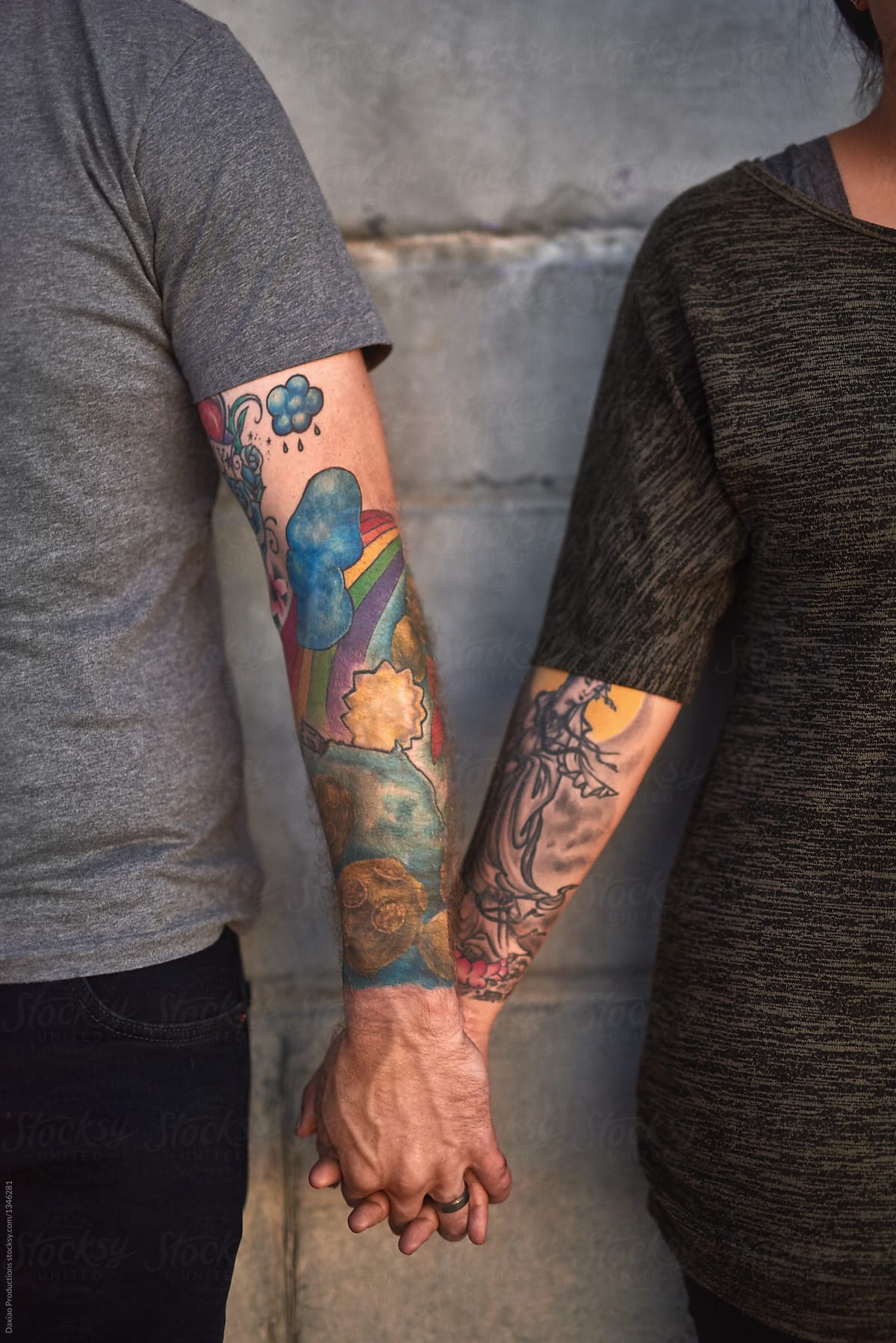 Tattooed couple holds hands