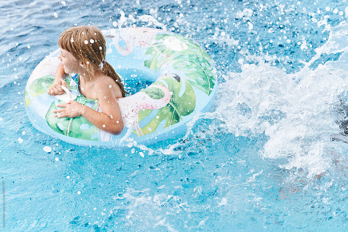 Cute little girl splashing in a swimming pool