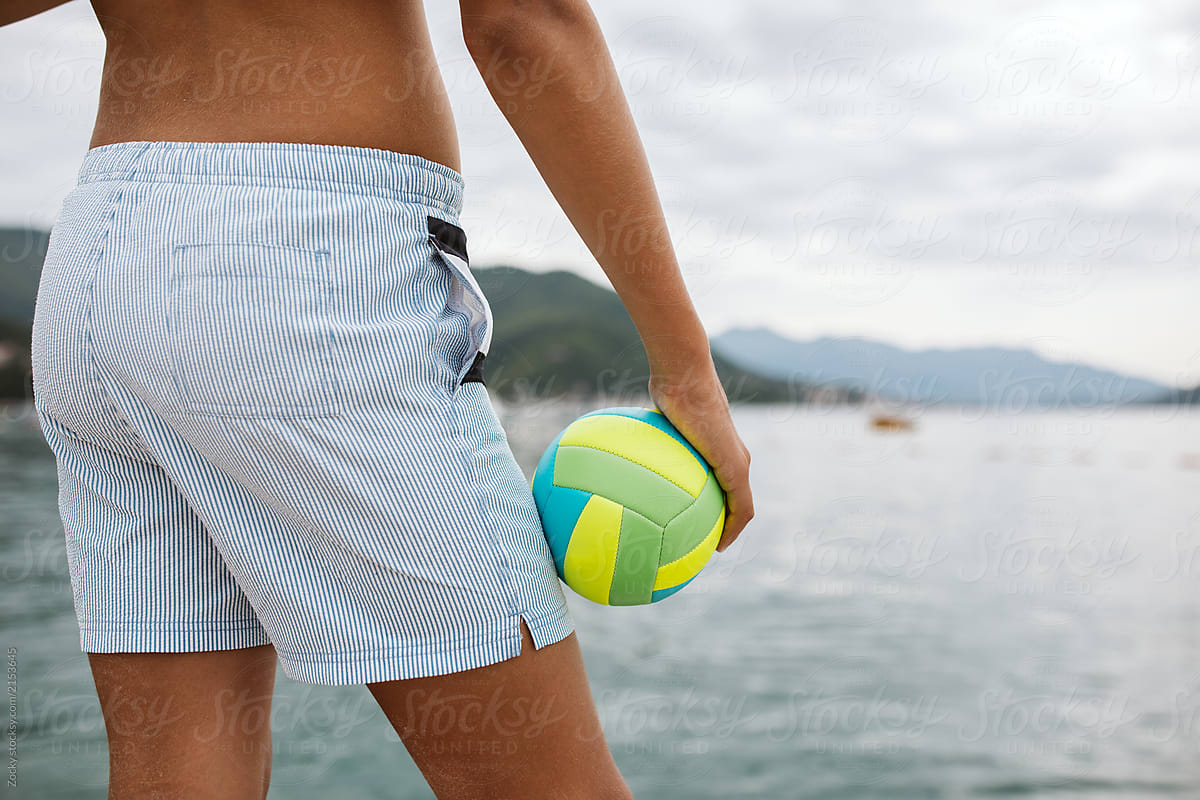 Beach volleyball. Close up of sporty boy standing with ball.