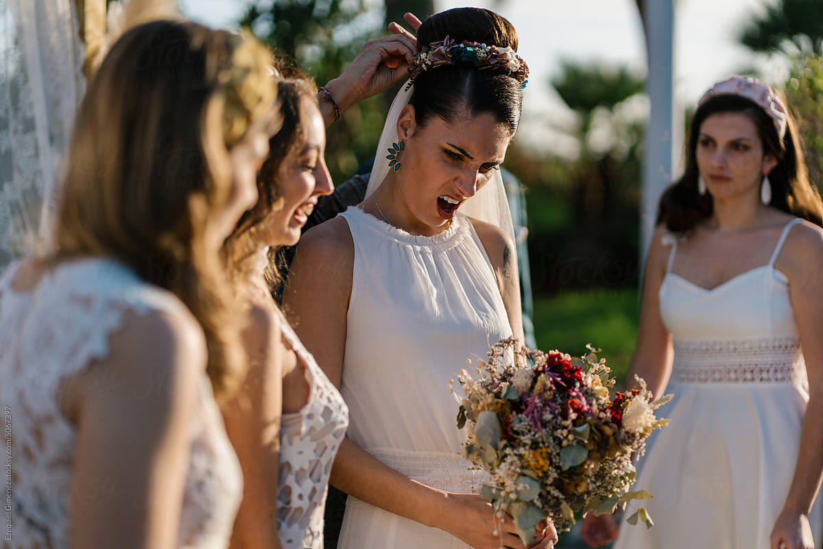 Displeased bride amidst bridesmaids in garden
