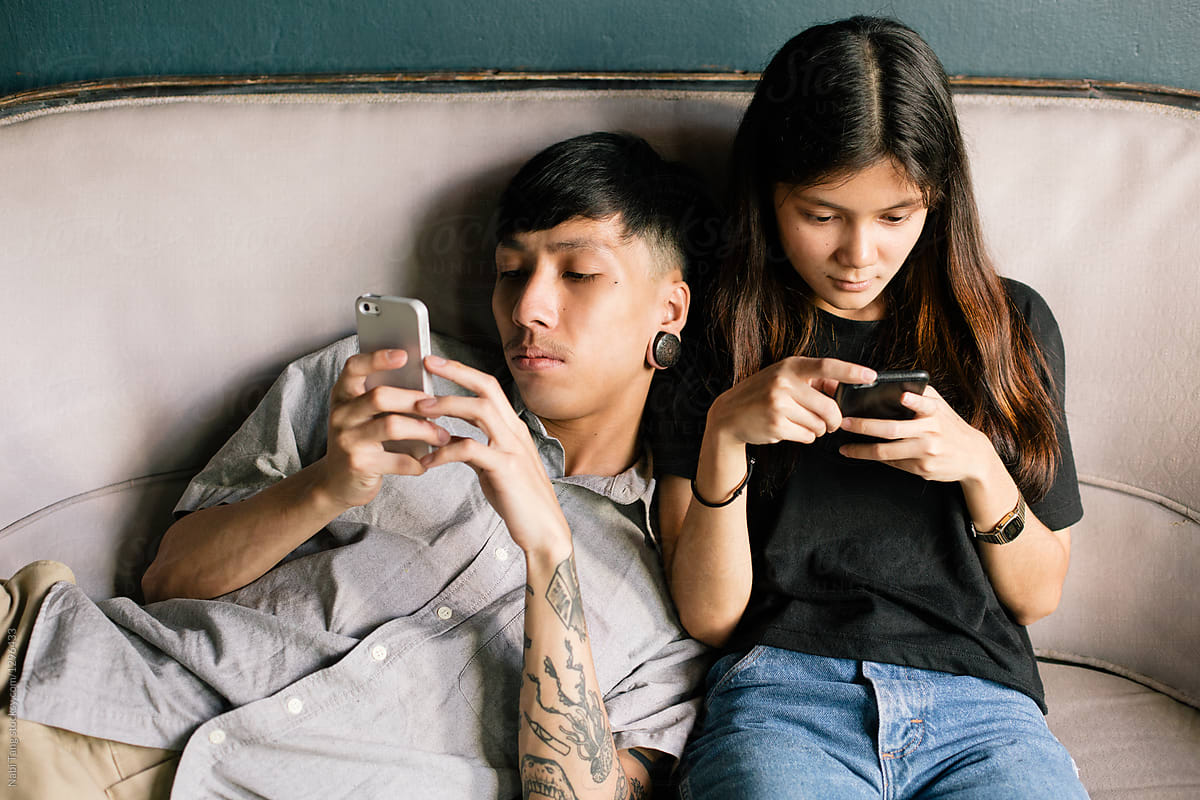 Young Asian couple using mobile phone together