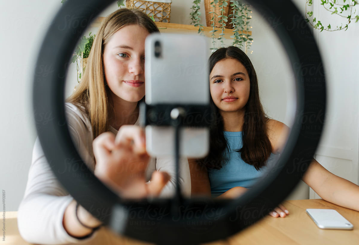 Teenage girlfriends shooting vlog with smartphone
