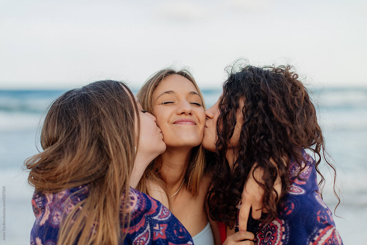 Two Girls Kissing Their Friend To Congratulate Her By Javier Pardina Stocksy United