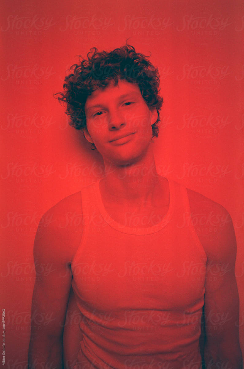 Handsome man looking at camera against red background