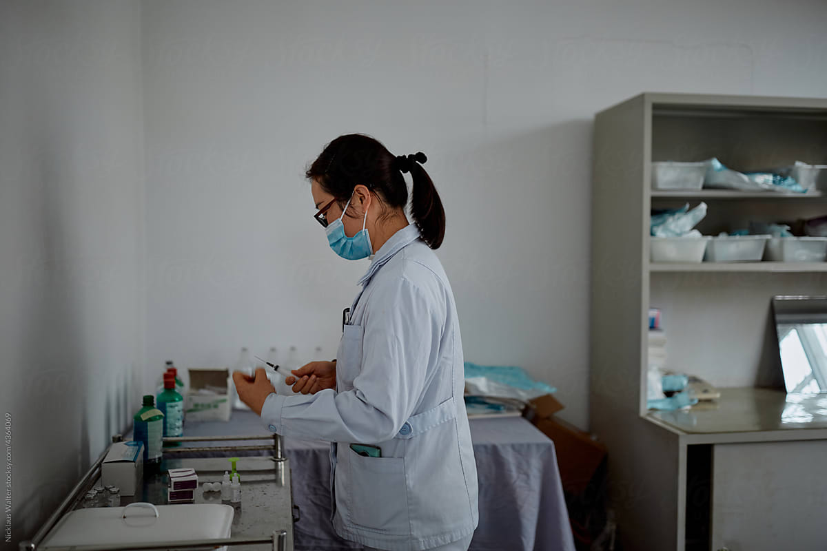 Female Chinese doctor prepares medicine at a hospital