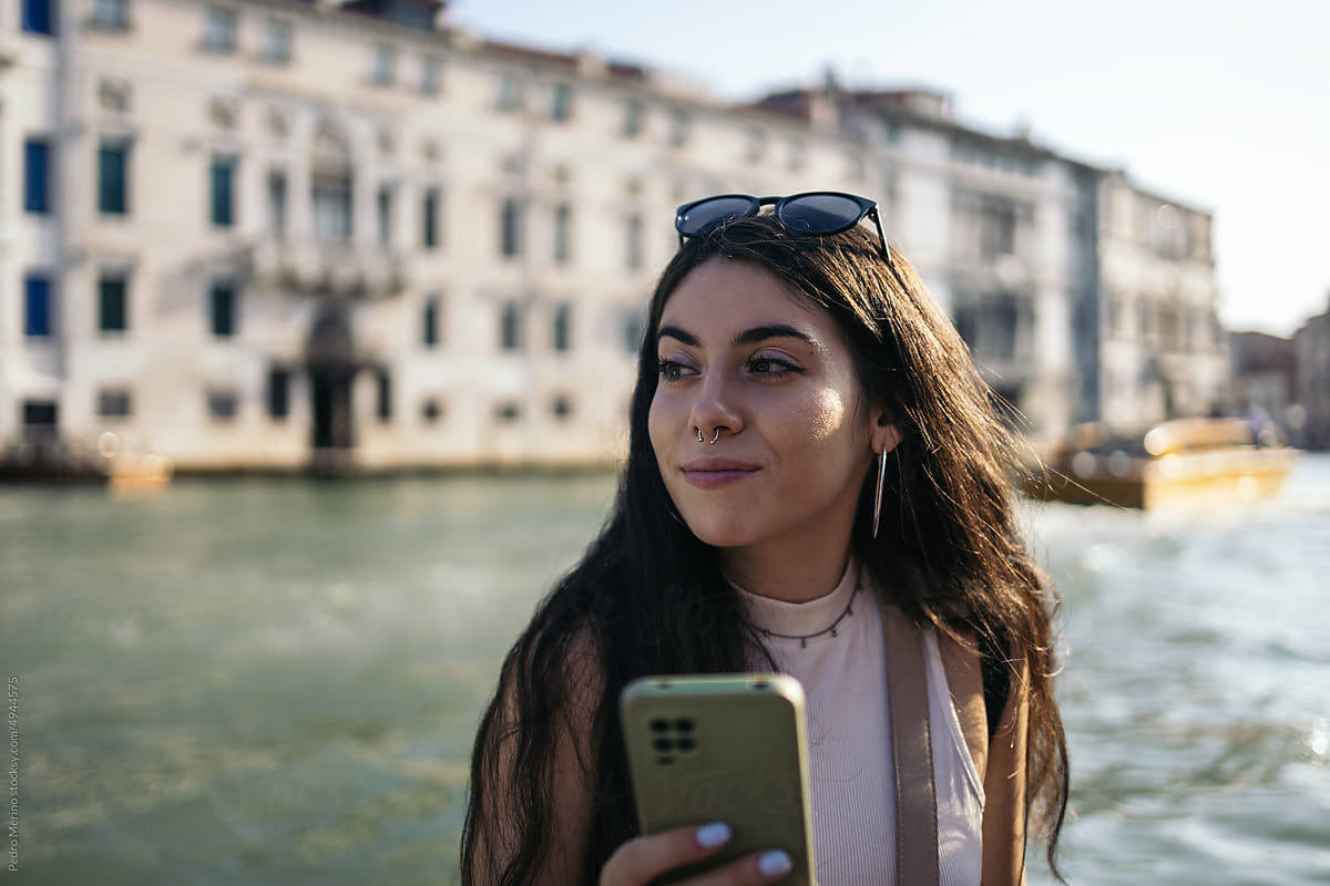 Portrait of young woman with smartphone in a gondola in Venice
