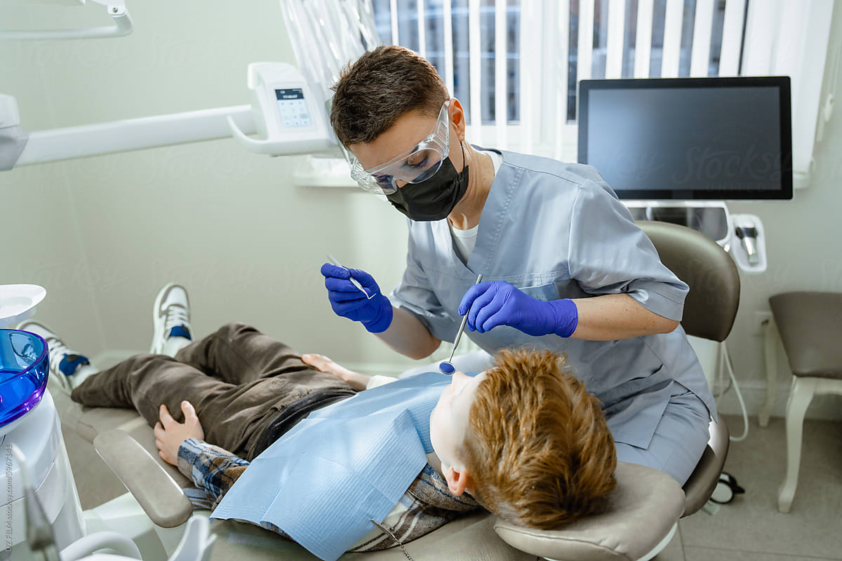 A dentist treats a child\'s teeth
