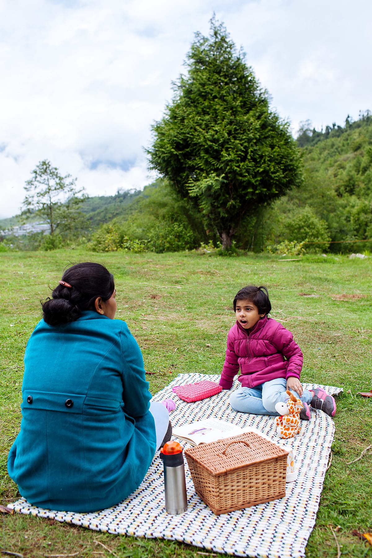 Mother and daughter enjoying a picnic in the hills