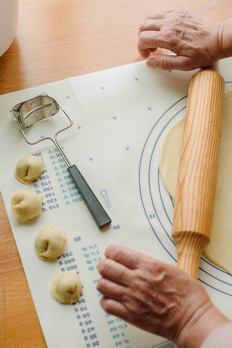 Woman’s hands roll the dough for dumplings