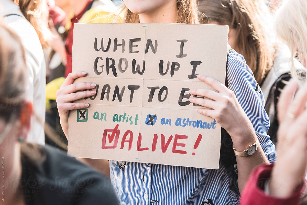 A young feminine protestor holding a sign