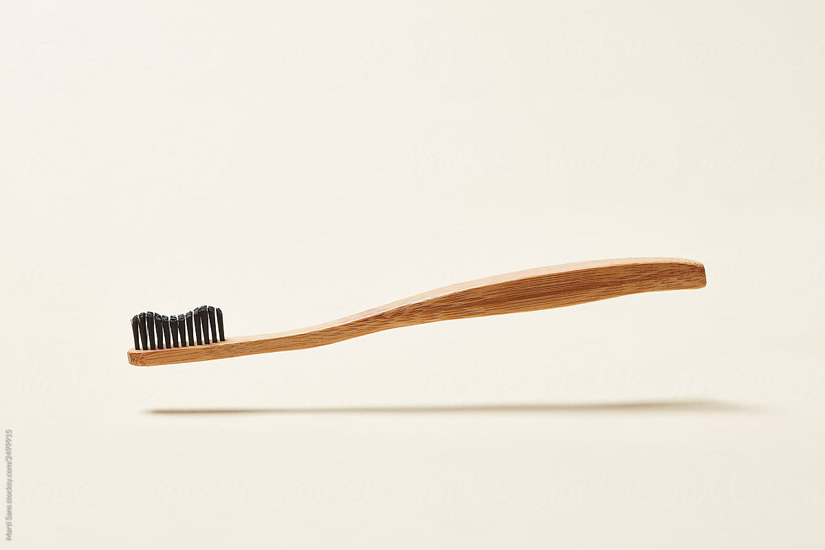 Minimalist wooden toothbrush above ground
