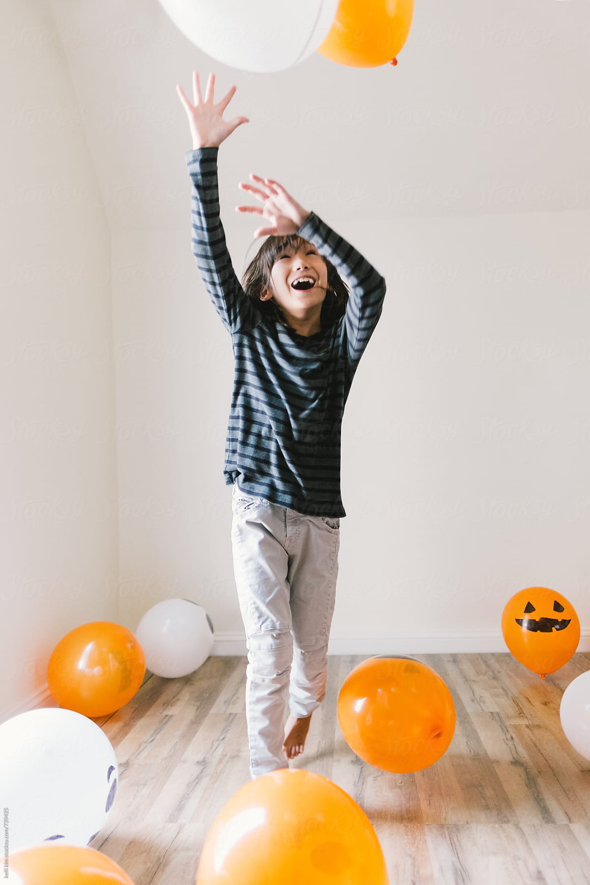 young boy plays with Halloween balloons