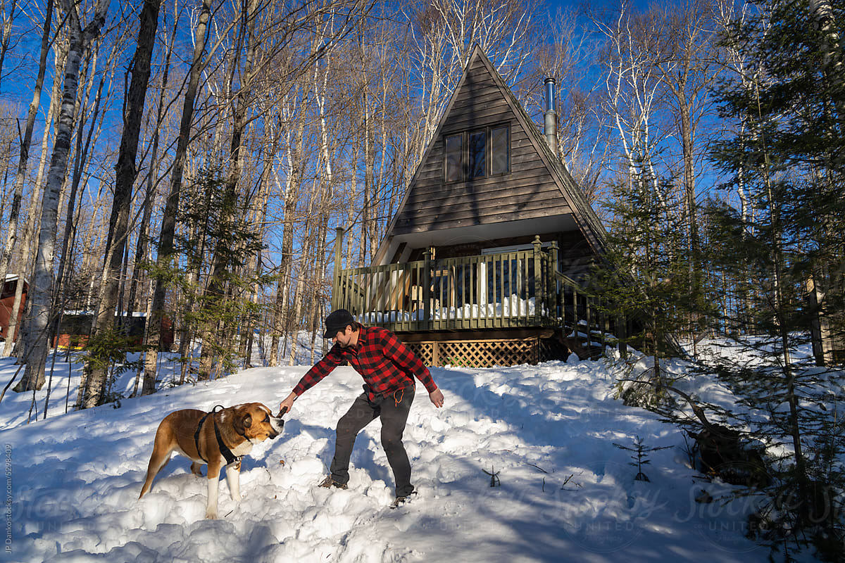 Man Playing With Large Dog at Winter Cottage