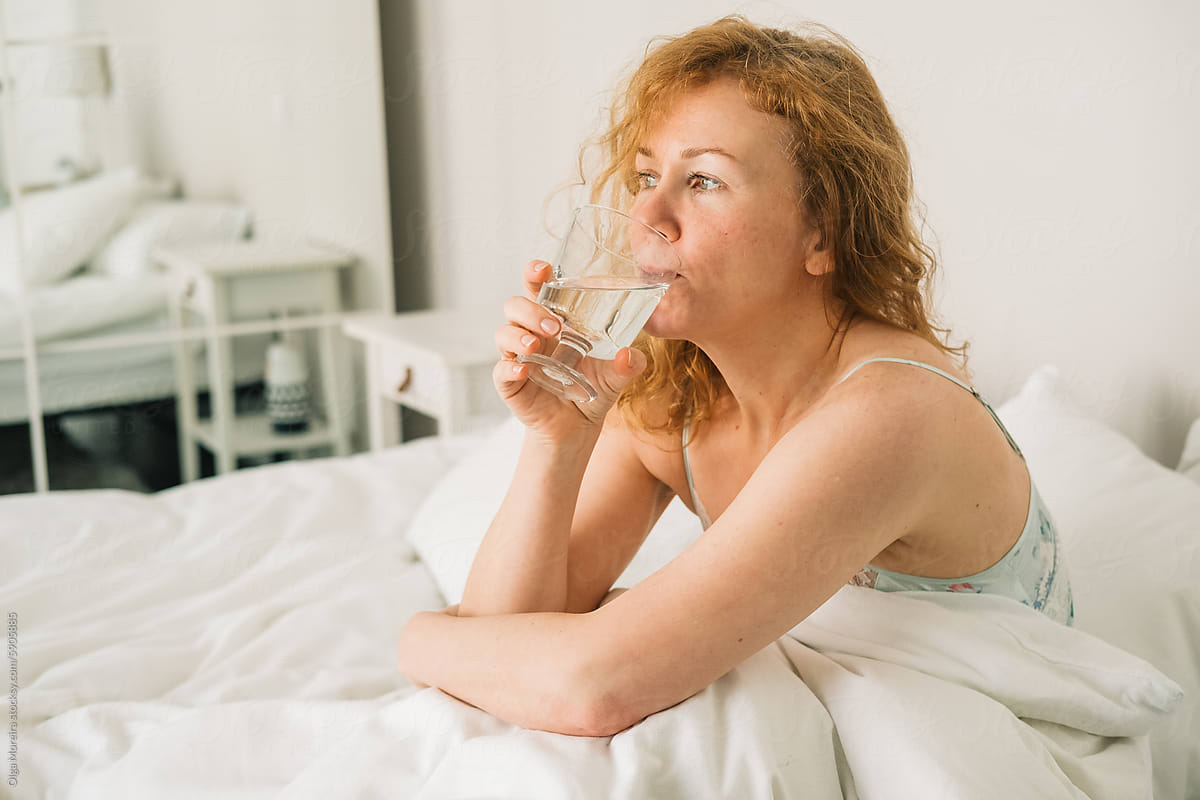 Woman drinking water in bed