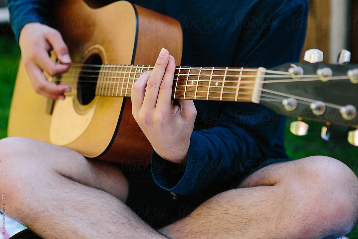 anonymous man playing acoustic guitar