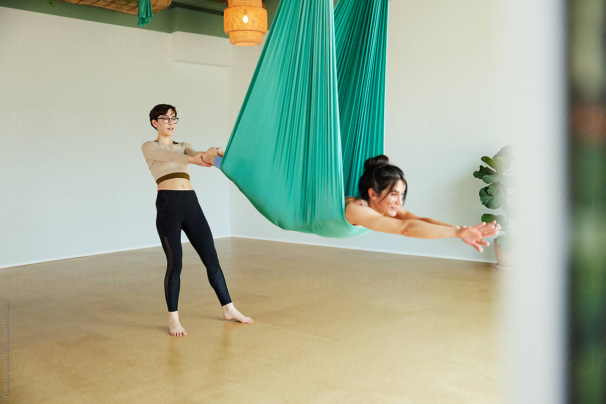 Aerial yoga teacher working with a student