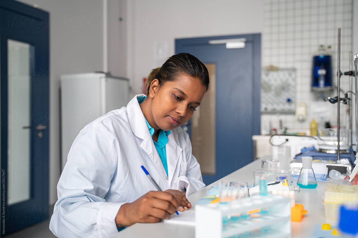 Scientist Writing Notes in Lab