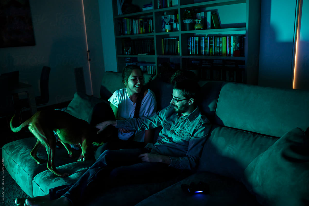 Cute couple playing videogames at night at home