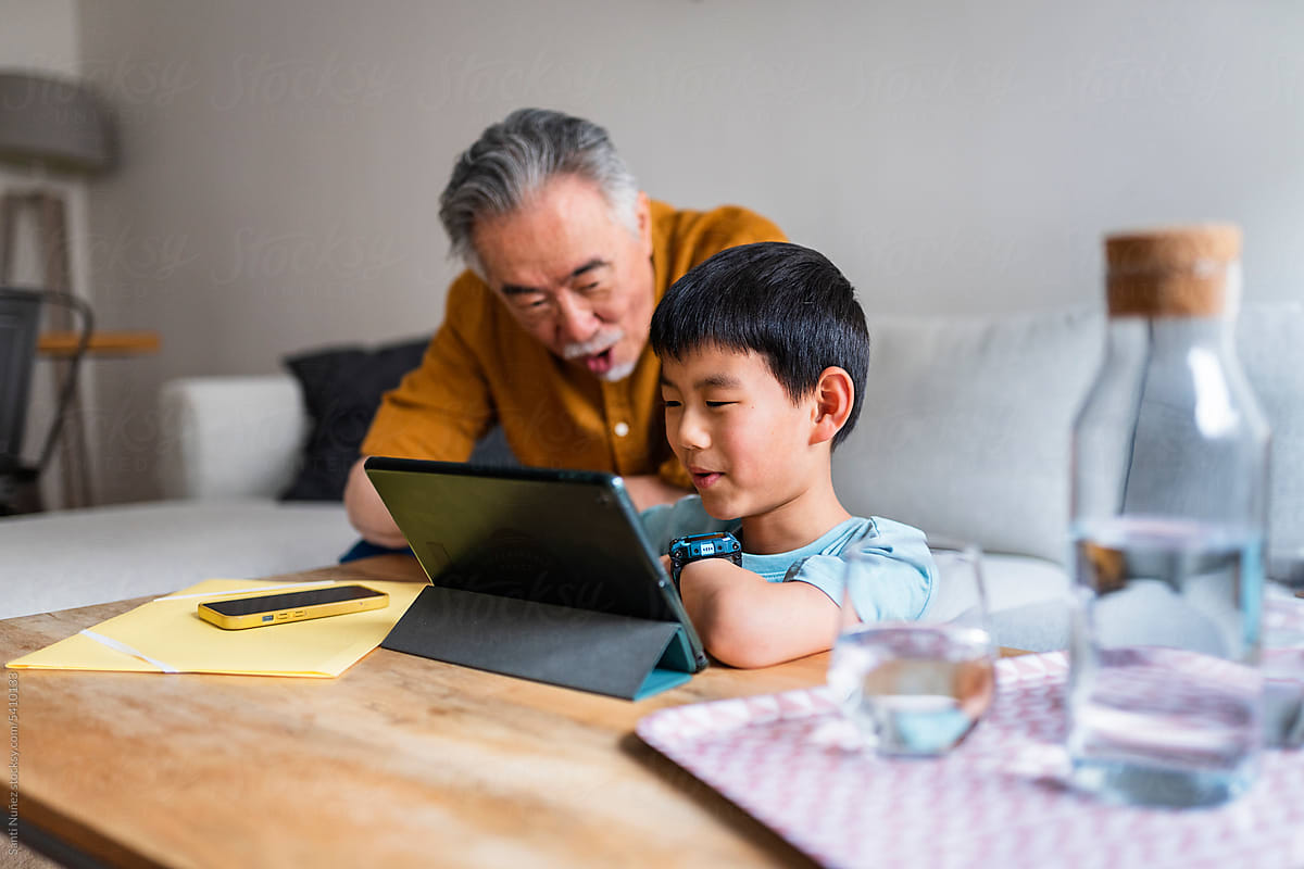 Grandpa and grandson using tablet.