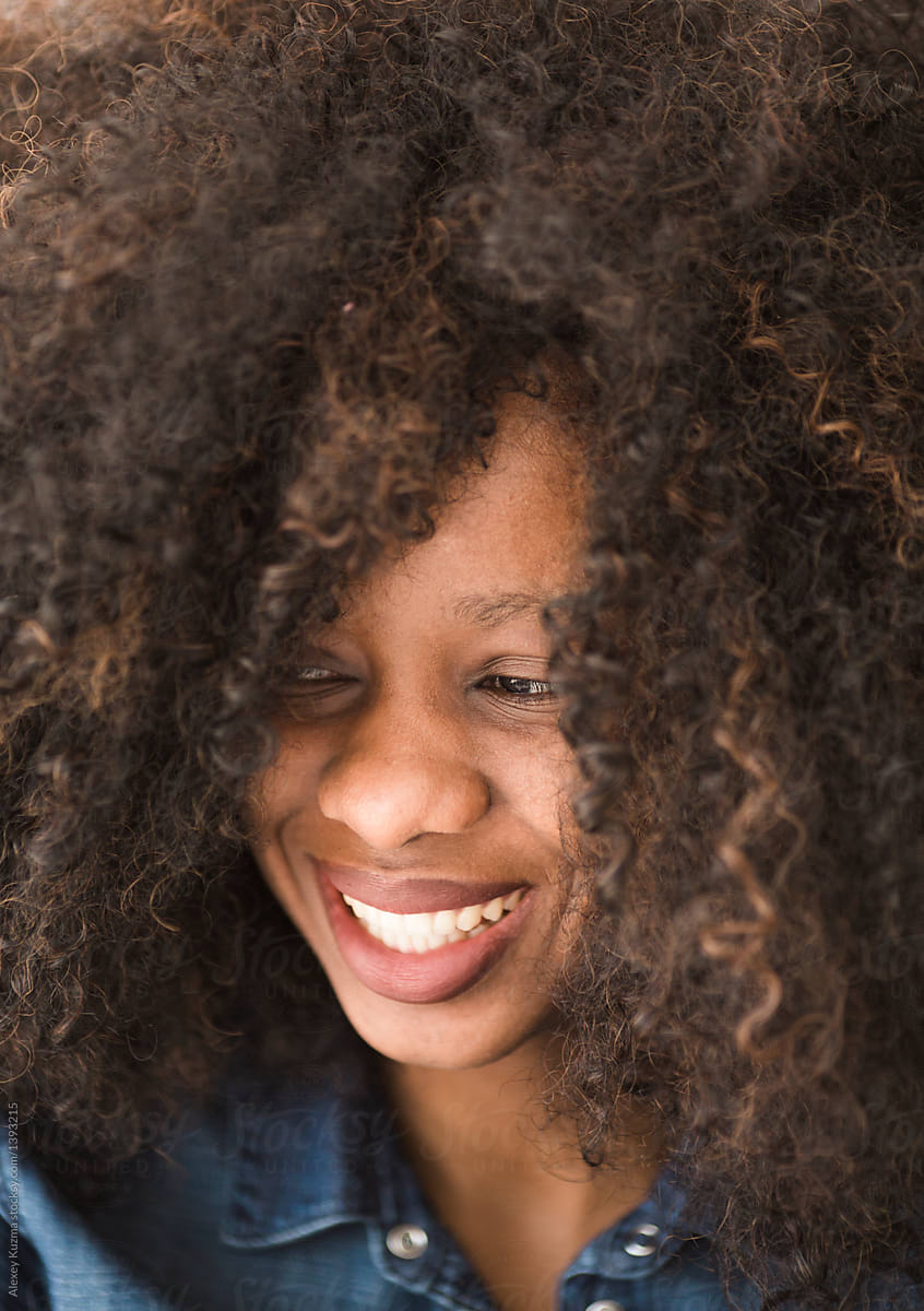 happy young african american woman with big curly hair