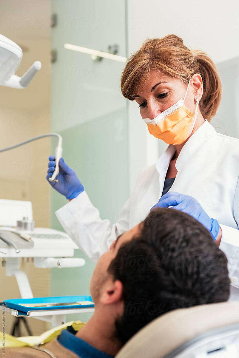 Dentist during a dental intervention with a patient.