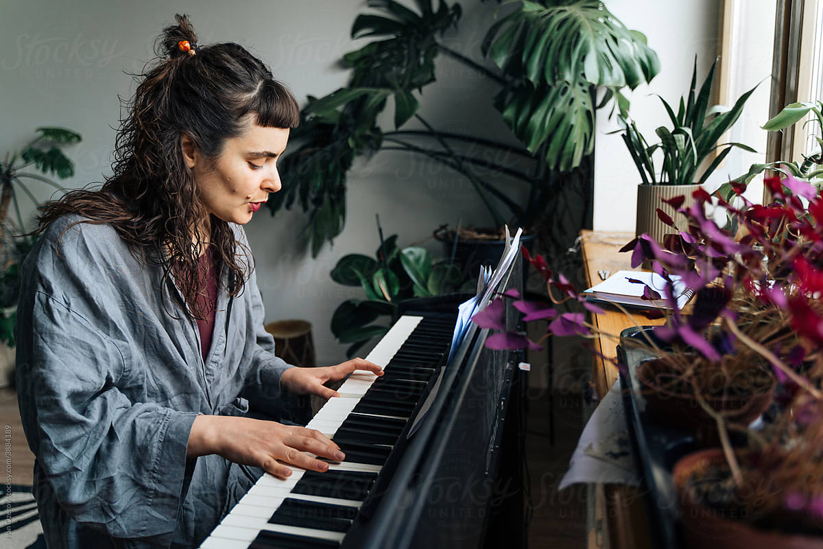 Female musician playing piano at home