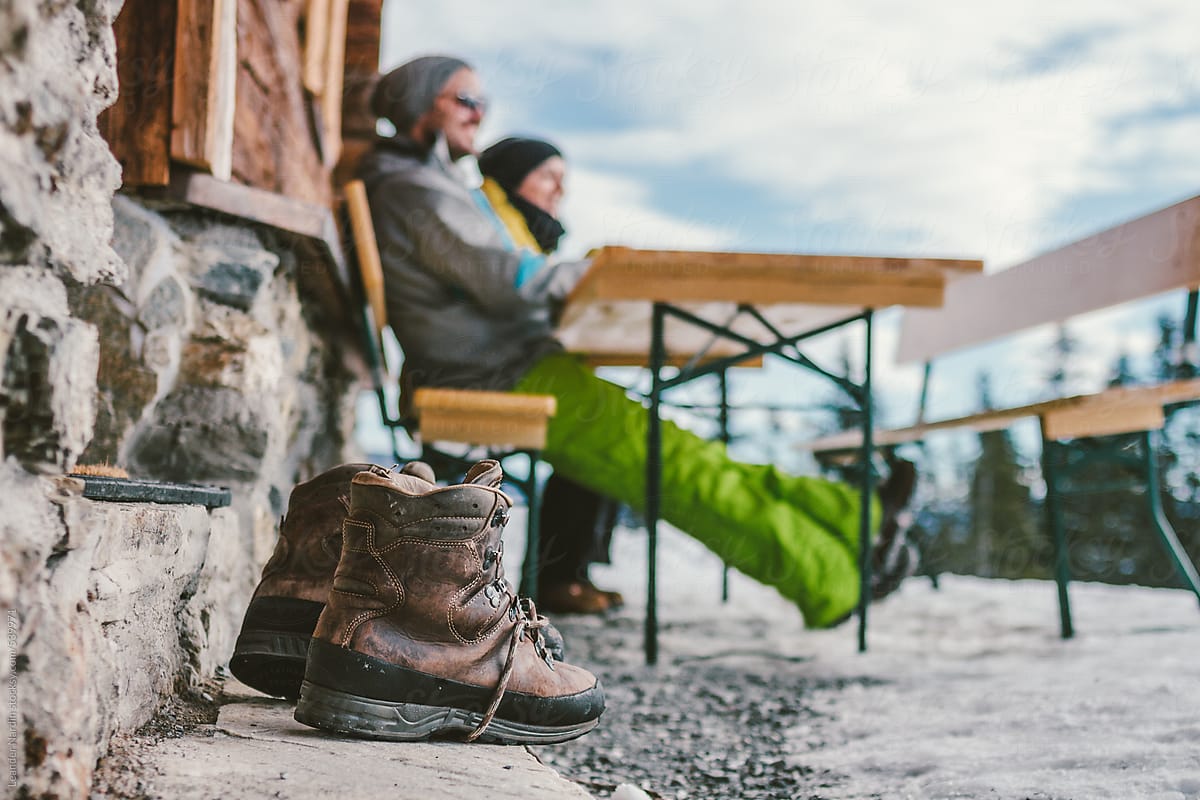 blurry couple sitting on a bench with a mountaineering boot in the front