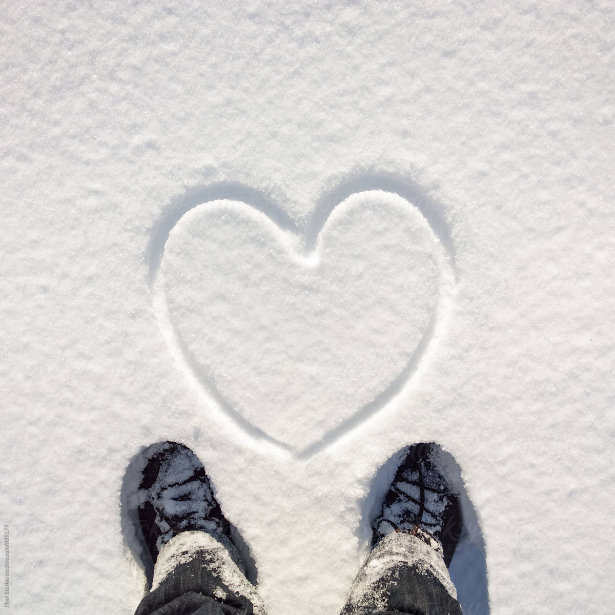 Person standing in front of snow heart