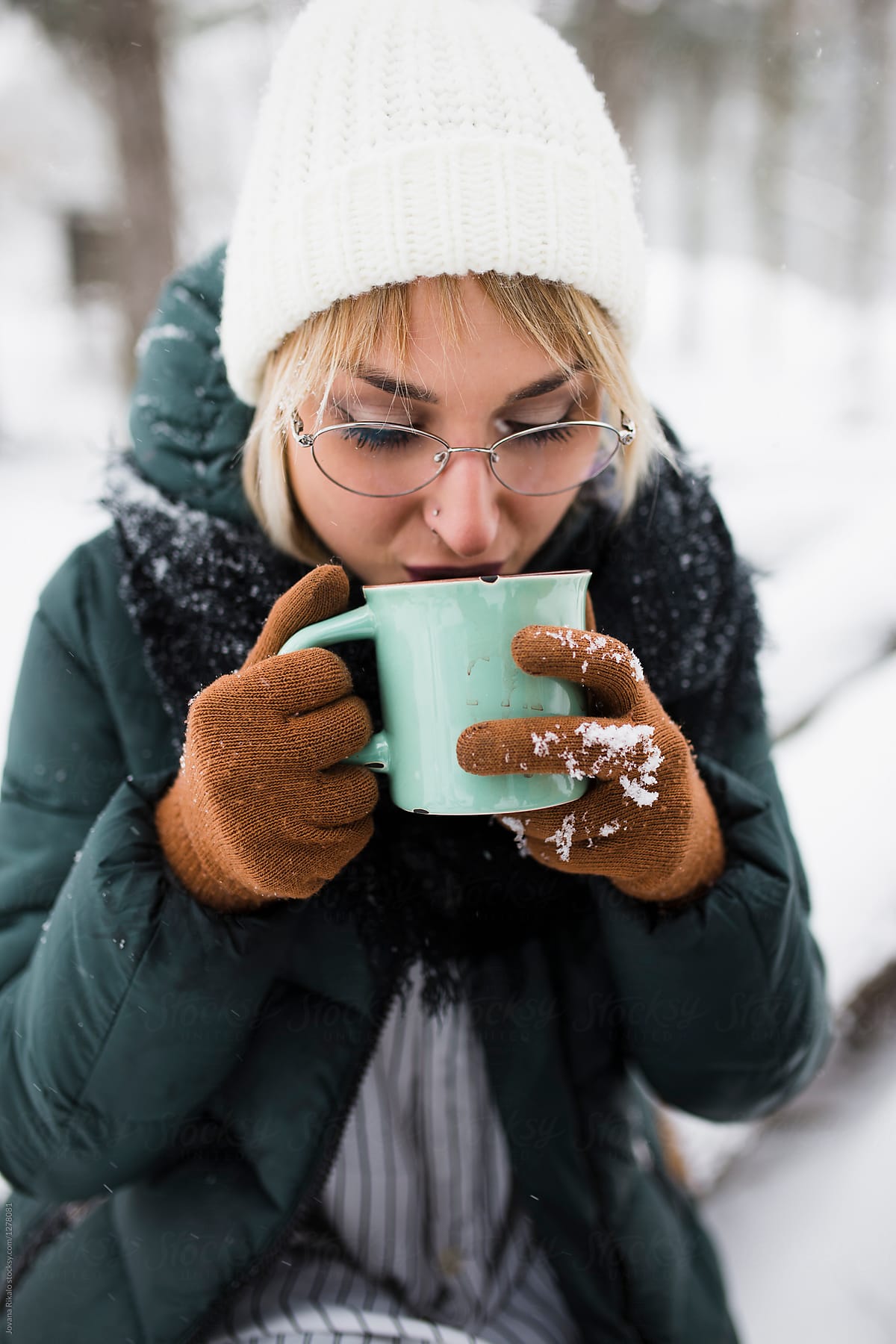 Young woman drinking mulled wine in snow