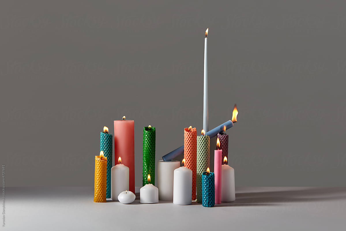 Burning beeswax candles in various shapes.