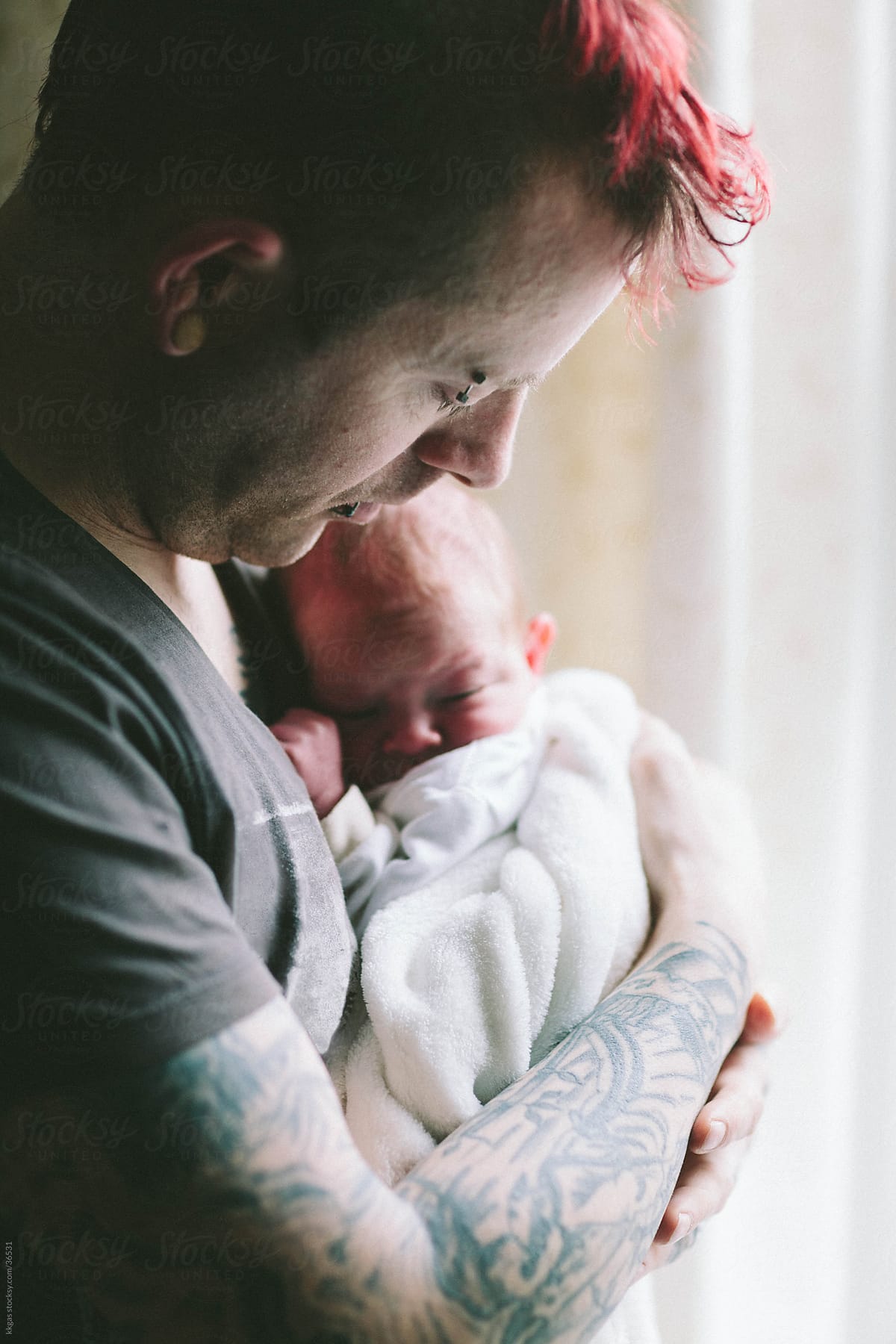 Newborn baby in dad\'s arms