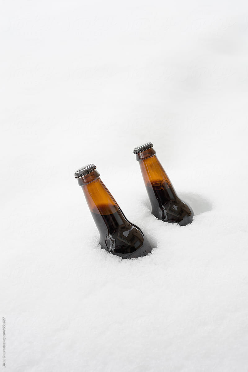 Two bottles of beer chilling in snow