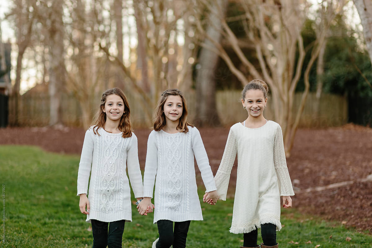 Three Sister Walking Together Holding Hands By Stocksy Contributor